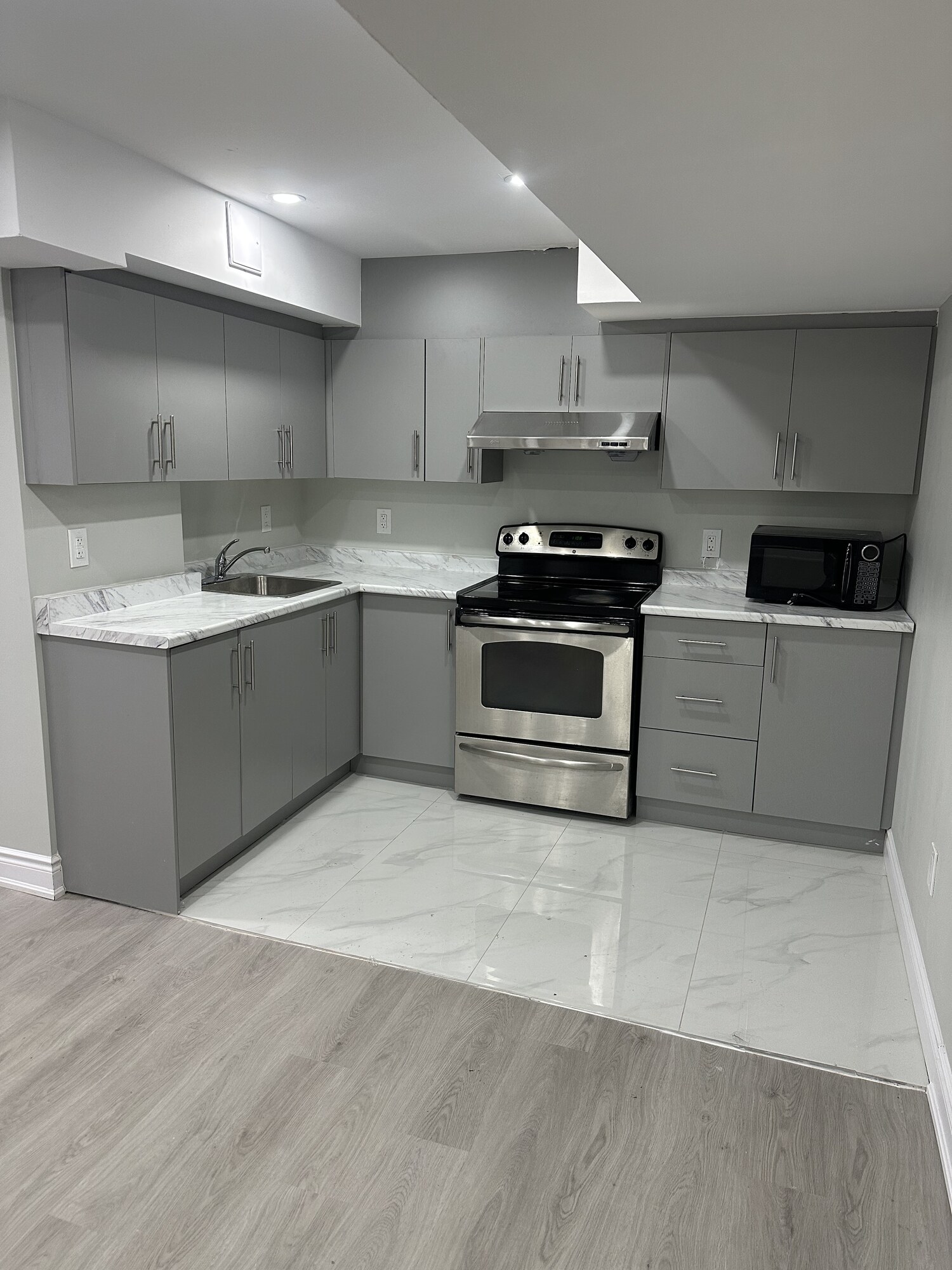 Basement Suite Kitchen — Grey Cabinetry & Marble Counters — Basements project by Redstone Construction in Brampton, ON
